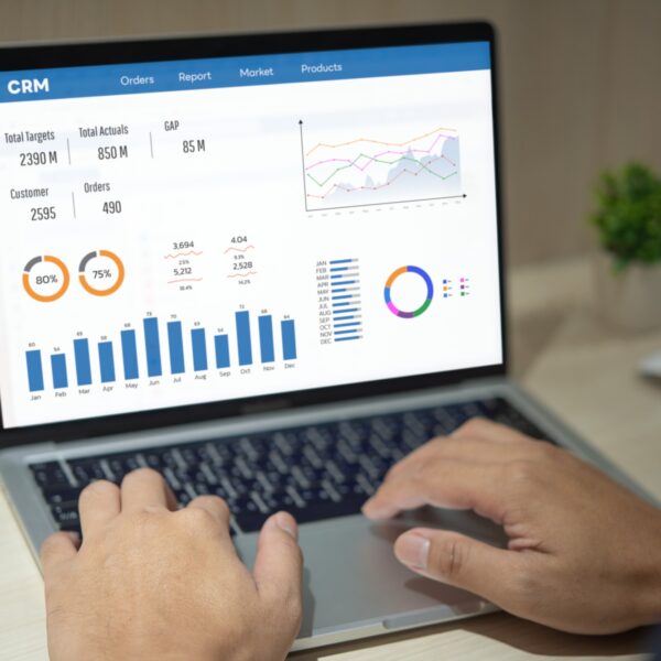 Man using computer laptop software with graphs and charts showing sales data. CRM Customer